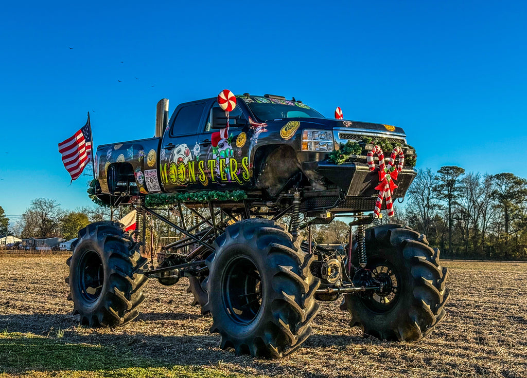 Monster truck with large wheels and festive decorations in a field